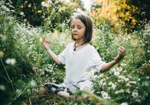 Girl sits in field of flowers after undergoing ADHD therapy in MA