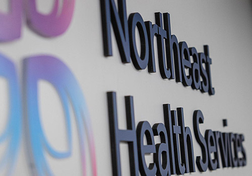 Northeast Health Services logo on a wall.