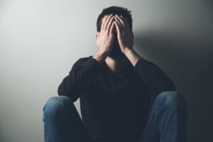 man with head in hands considers if alcohol and depression are linked