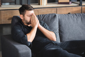 man sits on couch with high functioning anxiety