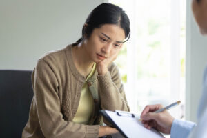 woman talks with provider holding a checklist about how to find a psychiatrist in boston