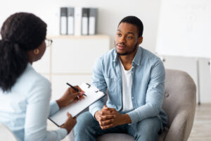 man talks with a psychiatrist in boston in a well-lit counseling room